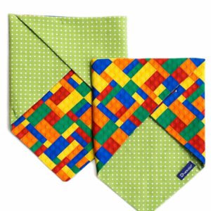 Bandana reversibile per cani in cotone con stampa mattoncini colorati su un lato e pois bianchi su fondo verde sull’altro. Reversible cotton dog bandana with colorful building block print on one side and white polka dots on green on the other.