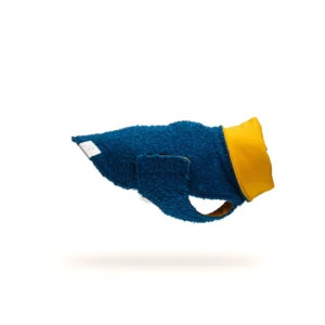 Jack Russell che indossa cappotto per cane in bouclé color petrolio con fodera ocra durante una passeggiata invernale