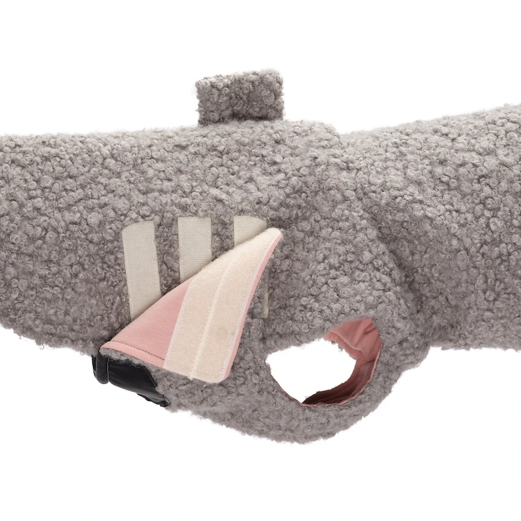 Due barboncini che indossano cappotti per cane in bouclé color acquamarina e rosa pastello con collo alto protettivo