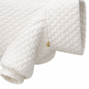 Top per cane in tessuto matelassé bianco con collo alto morbido e ciondolo a stella dorato. White matelassé dog top with soft turtleneck collar and small golden star charm.